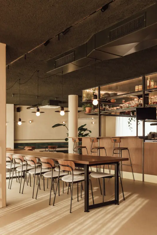 wnętrze restauracji Tilia eetcafé w Linden - dekoracyjne pendanty Modular Placebo Track 48V nad długim wspólnym stołem - realizacja Pan i Pani od Światła, Belgia